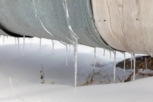 Overhead heat pipes. Winter, snow on the pipe