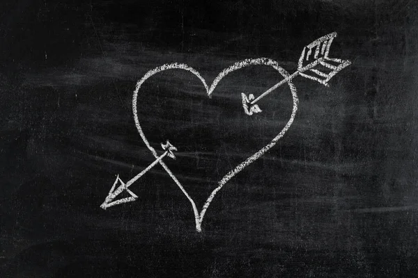 Heart symbol with arrow on chalk board, love symbol.