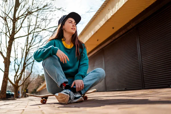 Молода Красива Кавказька Жінка Сидить Розслаблена Скейтборді Дивиться Геть Задньому — стокове фото