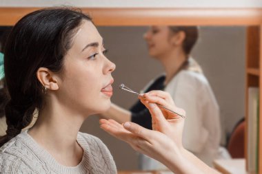 Doktor, kızın diline masaj yapar, ses tonuna uygun olsun diye..