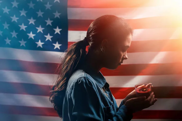 悼念日一个女人拿着一支蜡烛纪念受害者 在背景上 美国国旗 侧视图 美国假日的概念 — 图库照片