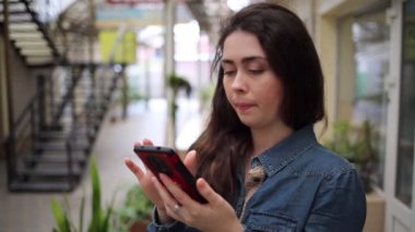 İnternet ve sosyal ağlar. Genç, güzel, esmer kadın cep telefonundan arıyor.