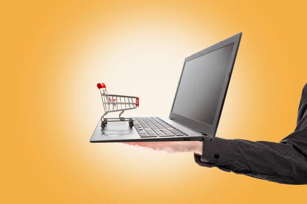 Shopping Man Hand Holds Laptop Mini Grocery Cart Standing Orange — Stock Photo, Image