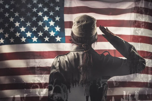 Celebration in the USA. A female soldier saluting, against the background of the American flag. Rear view. Multi-exposure.
