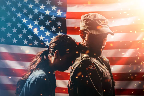 这是个重要日子女人把头靠在士兵的背上 士兵转过身来对她说 挂着火花的美国国旗背景上的一对 美国国定假日的概念 — 图库照片