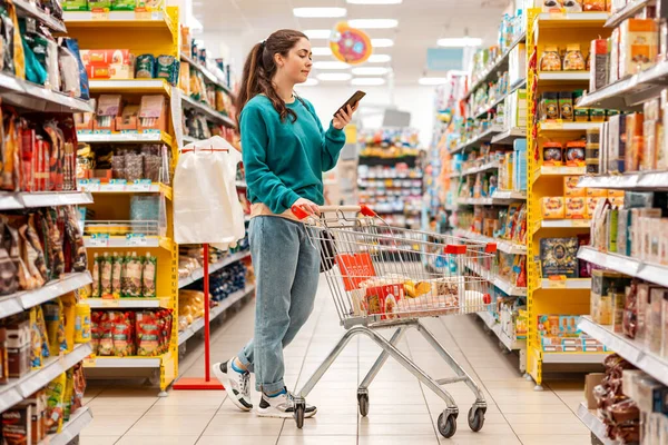 Young Pretty Caucasian Woman Casual Clothes Pushing Grocery Cart Using — Stock Photo, Image