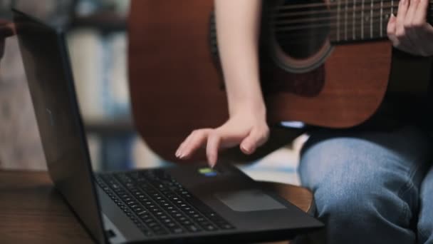 Женщина Печатает Ноутбуке Держит Гитару Закрывай Онлайн Обучение Игре Музыкальных — стоковое видео