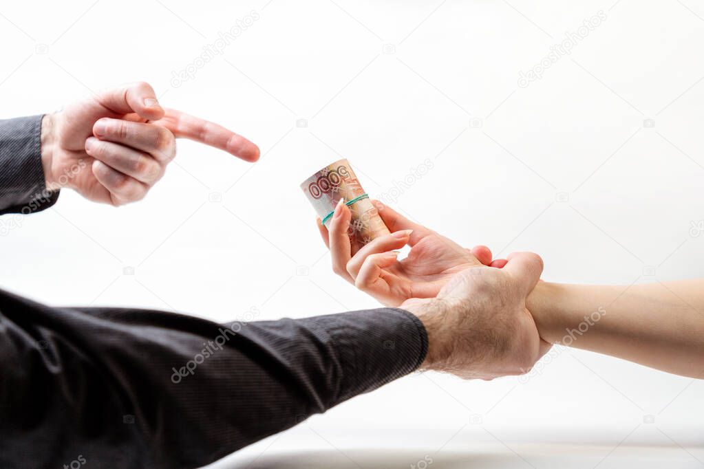 Bribery. A man's hand in a black shirt catches a woman's hand with a bribe. Side view. White background. The concept of the world anti-corruption day.