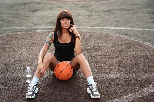 Красива Молода Жінка Татуюваннями Позує Баскетболом Сидить Землі — стокове фото