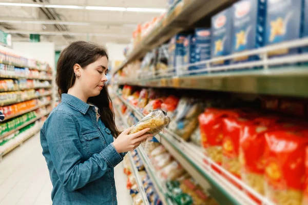 Fare Spesa Supermercato Una Giovane Donna Camicia Jeans Legge Informazioni — Foto Stock