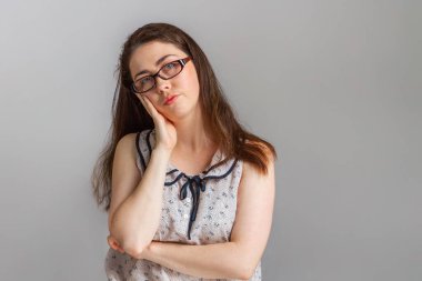 Duygular ve insanlar. Gözlüklü ve bluzlu genç bir esmer çenesini eline dayadı ve başını eğdi. Beklenti ve tatminsizlik duygusu..