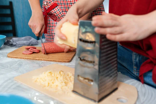 Birkaç kadın mutfakta birlikte yemek hazırlıyor. Kapatın. Yan görüş. Ev yemeği ve LGBT ilişkileri kavramı.