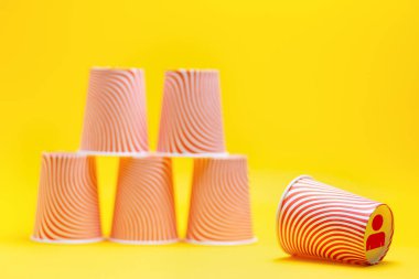 Kağıt bardak piramidi. Piramidin tepesindeki cam altta, altta bir kişinin sembolü bulunuyor. İş yerinde tükenme, işten çıkarma ve yönetim kavramı.