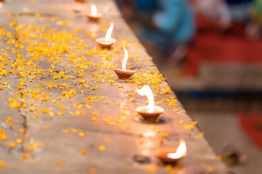 Hindu Diwali festivali. Çiçek yaprakları serpiştirilmiş bir masanın üzerinde duran mumları yakmak. Üst görünüm, yakın çekim.