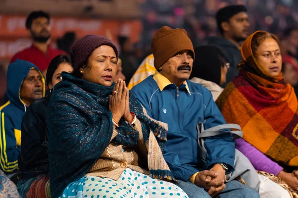 17.12.2019, Varanasi, Hindistan. Arati 'nin kutsal dini töreni. Bir grup insan oturup dua ediyor ve dini bir eylemi izliyorlar..