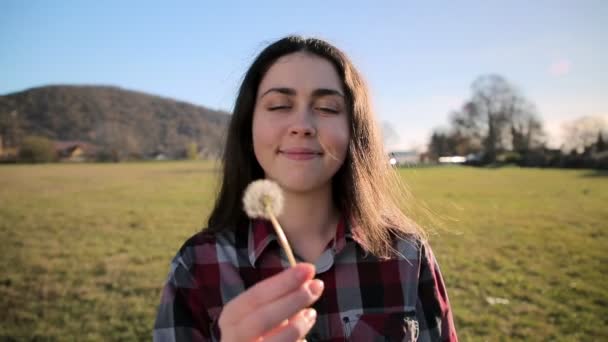 Portret Van Een Jonge Gelukkige Vrouw Die Een Paardebloem Uitblaast — Stockvideo