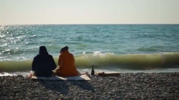 Paio Persone Giacca Sedute Sulla Spiaggia Fare Picnic Sullo Sfondo — Video Stock