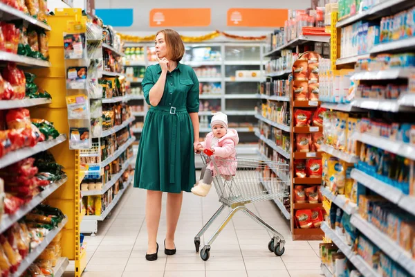 Winkelen Winkel Een Jonge Peperdure Moeder Rolt Een Boodschappenkarretje Met — Stockfoto