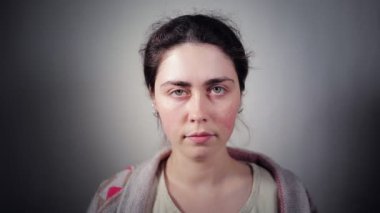 Hasta görünümlü genç bir beyaz kadın yüzüne tıbbi maske takıyor. Karanlık arka plan. Viral enfeksiyonlara karşı koruma kavramı.