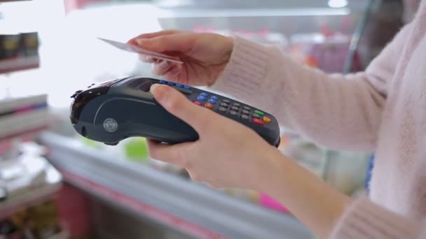 妇女在支付终端上使用银行卡 手举得很近在后台购买Windows 用银行卡进行采购的概念 — 图库视频影像