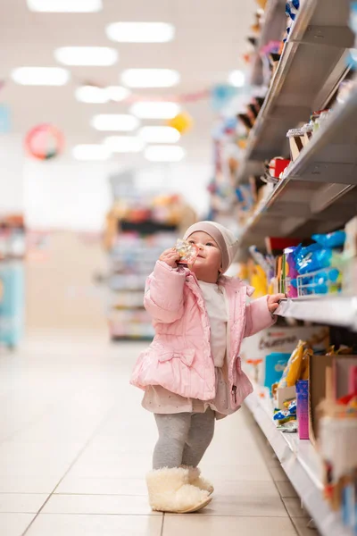Compras Familiares Uma Criança Pequena Bonito Fica Perto Prateleira Com — Fotografia de Stock