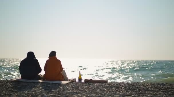 Kilkoro Ludzi Kurtkach Siedzących Plaży Urządzających Piknik Tle Ocean Fale — Wideo stockowe