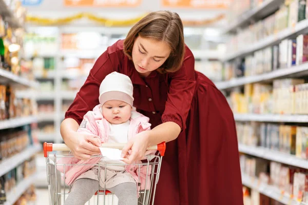 Retrato Jovem Mãe Uma Lista Compras Mostrando Seu Bebé Conceito — Fotografia de Stock