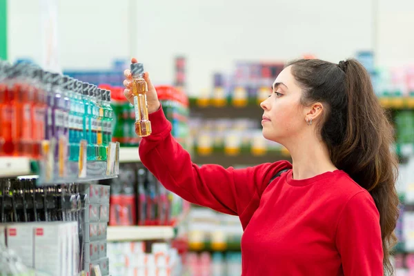 Egy Fiatal Portréja Amint Információt Olvas Egy Üveg Kozmetikumról Oldalnézetből — Stock Fotó