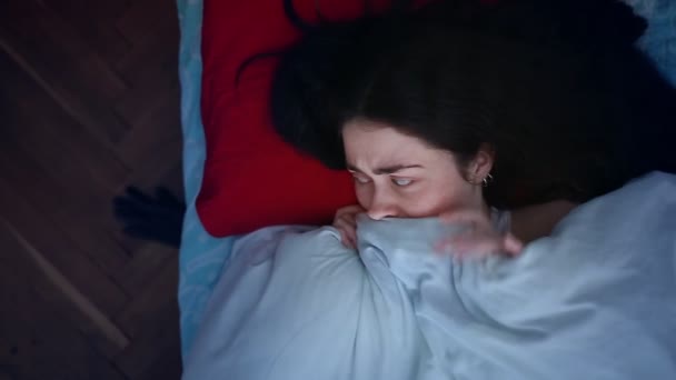 ベッドの怪物から毛布の下に隠れて 何か怖いものを見た後 若い女性はベッドで怖がっています 上からの眺め 不眠症や悪夢の概念 — ストック動画