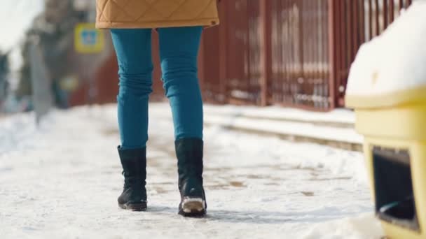 女性が慎重に雪に沿って歩くと パスをカバーするように滑りません 一番下だ 足のクローズアップ スローモーション — ストック動画