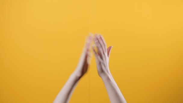Kvinnliga Händer Framträder Underifrån Och Roliga Applåder Gul Bakgrund Begreppet — Stockvideo