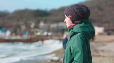 Genç bir kadın sahilde duruyor ve nebulizatörün içinde ilaç soluyor. Parallax. Astımın muhafazakar tedavisi kavramı.