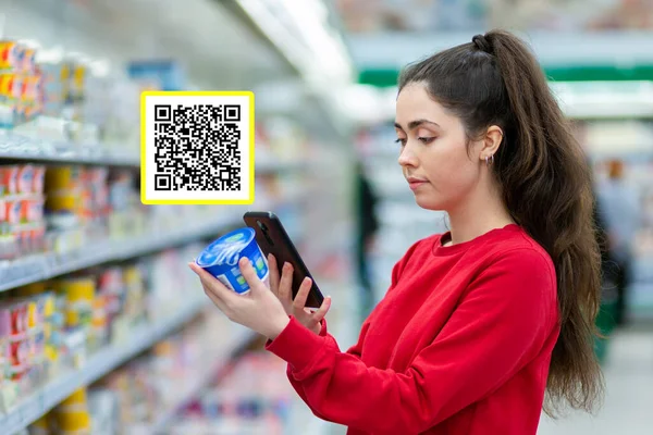 Shopping. A young pretty woman scans the qr code on a product using cellphone. Qr code icon above the product. Concept of modern technologies and shopping.