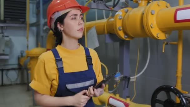 近代的な産業と製造コンセプト 女性エンジニアは生産室を歩き タブレットに圧力計の測定値を書き込みます — ストック動画