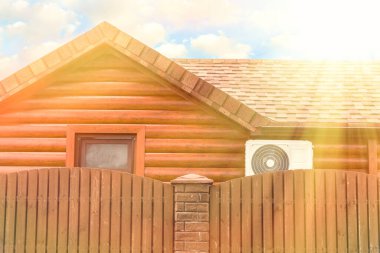 Klimalı ahşap ev, çitlerle çevrili. Sıcak güneş ışığı. Yaz ve sıcak.