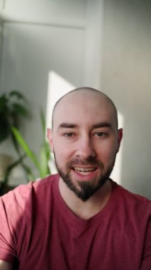 Genç sakallı bir adam aboneleriyle canlı yayında. Çevrimiçi yayın kavramı. Dikey