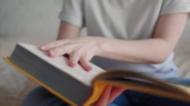 Kadınların elleri bir kitabın sayfalarını çevirir. Kapatın. Dünya Kitap Günü konsepti.