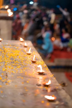 Hindu Diwali festivali. Çiçek yaprakları serpiştirilmiş bir masanın üzerinde duran mumları yakmak. Arka plan bulanık. Üst görünüm, yakın çekim.