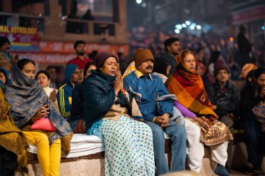 17.12.2019, Varanasi, Hindistan. Arati 'nin kutsal dini töreni. İnsanlar oturup dua eder ve dini eylemleri izlerler..