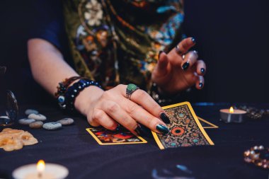 Bir büyücü falcı kartlarını masaya serer tarot. Eller yakın çekim. Kart okuma, sihir ve ezoterizm kavramı..