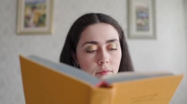 Genç bir kadın kitap okuyor, içinde neler olduğuna şaşırıyor. Kapatın. Dünya Kitap ve Eğitim Günü kavramı