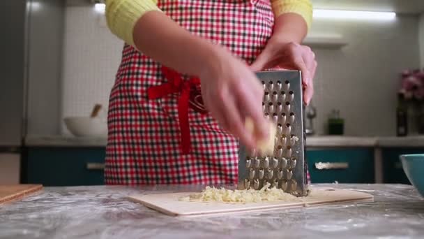 Hausmannskost Eine Frau Einer Schürze Reibt Käse Auf Einer Reibe — Stockvideo