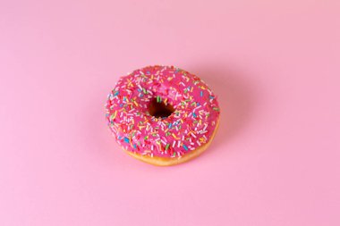 Pembe kremalı yuvarlak çörek. Üst Manzara. Pembe arka plan. Boşluğu kopyala.