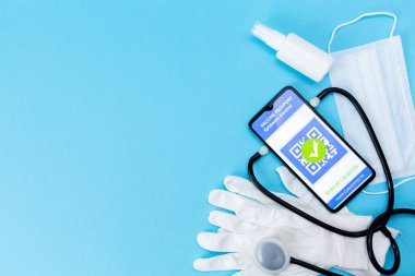 İlaç ve sağlık. Akıllı telefon ekranında COVID-19 aşısı olan elektronik bir dokunulmazlık pasaportu stetoskop, antiseptik ve koruyucu eldivenler. Düz yatıyordu. Boşluğu kopyala.
