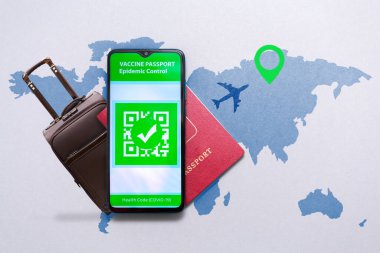 Seyahat aşısı kavramı. Pasaportu ve bavulu dünya haritasında olan akıllı telefon ekranında COVID-19 aşı damgalı elektronik dokunulmazlık belgesi..