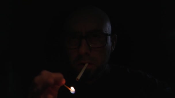 Homem Escuro Acende Fósforo Para Acender Cigarro Uma Luz Verde — Vídeo de Stock
