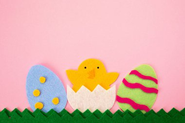 İki renkli yumurtanın keçeli tellerini kesersek tavuk yumurtadan çıkar. Pembe arka plan. Düz yatıyordu. Uzayı kopyala Paskalya tatili konsepti.