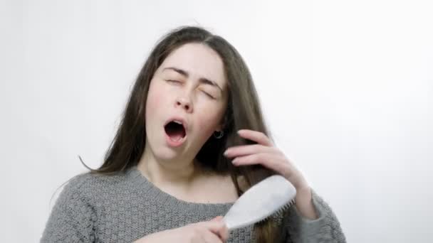 Seorang Wanita Muda Yang Lelah Menyisir Rambutnya Menguap Dan Tertidur — Stok Video