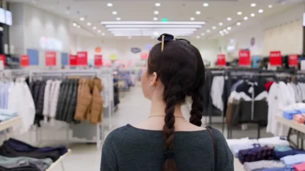 Uma Jovem Mulher Bonita Está Andando Por Uma Loja Roupas — Vídeo de Stock