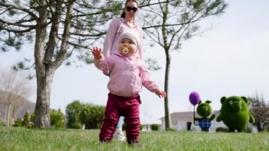 Bebek kameraya yaklaşarak yürümeyi öğreniyor. Alt manzara, yakın plan. Çocuk Günü.